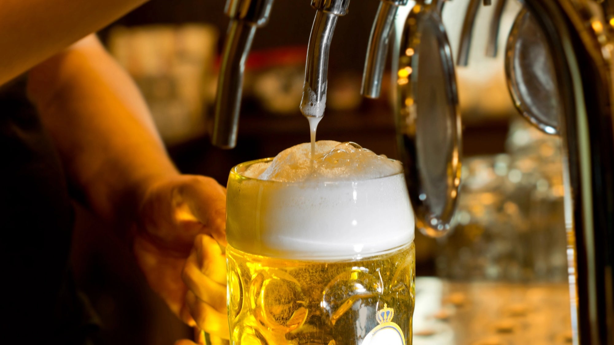Close up of hand pouring beer draft into stein